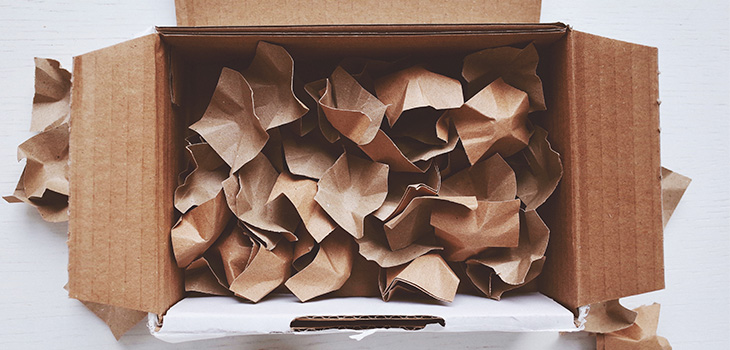 Caixa de papelão aberta com enchimentos de papel dentro para proteger os produtos